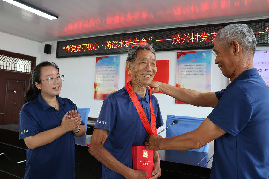 向老党员发放“光荣在党50年”纪念章（王华 摄）
