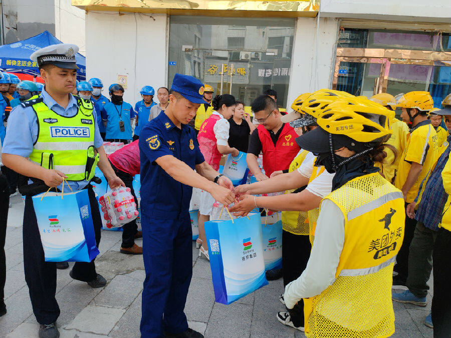 灌南县各单位、各爱心企业和志愿服务组织代表向新就业群体发放“夏送清凉”活动慰问物资（赵占成 摄）