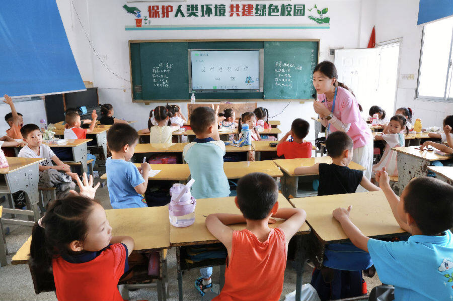 大学生志愿者对小朋友们进行课业辅导。（吴勇 摄）