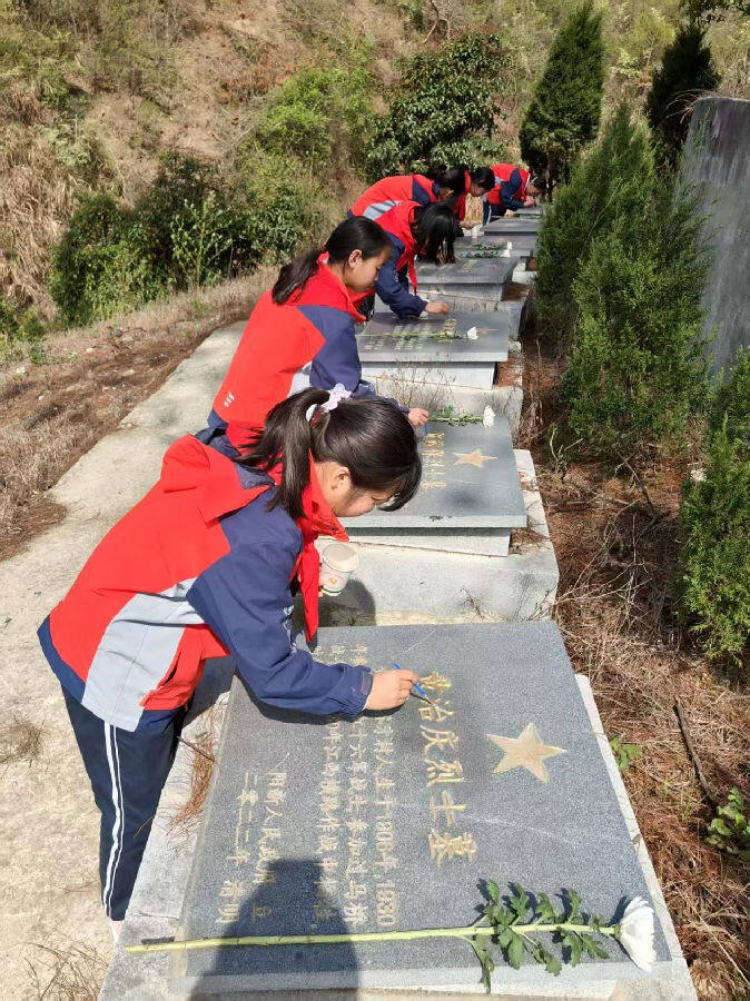 图为学生们仔细擦拭先辈们名字（倪胜林 摄）