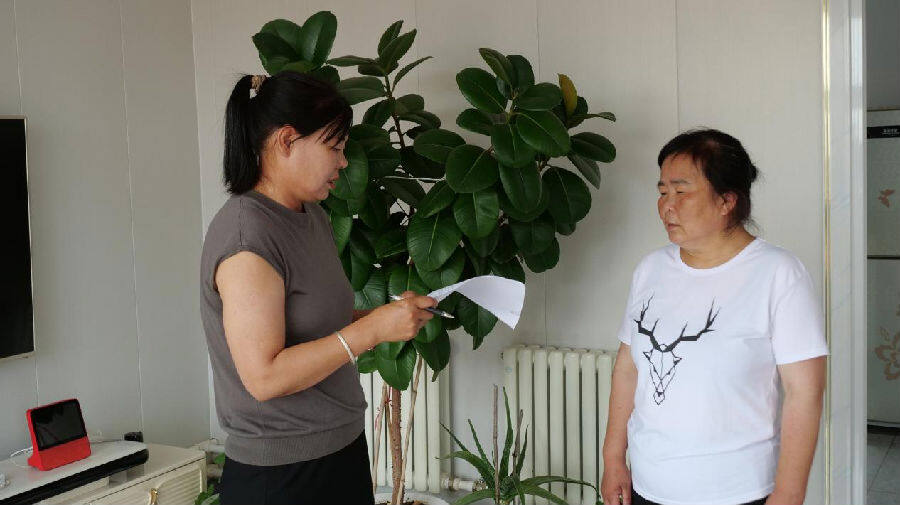 李翠玲（左）正入户打分 （杨景欣 摄）