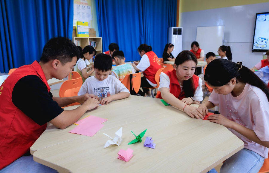 红军小学爱心托管班的孩子在志愿者带领下做手工（邹景根 摄）