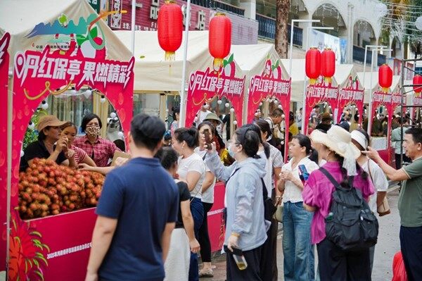 色泽鲜艳的红毛丹引得市民游客纷纷驻足。（文宏武 摄）