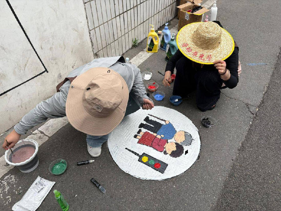 志愿者彩绘窨井盖。（王钟旗 摄）