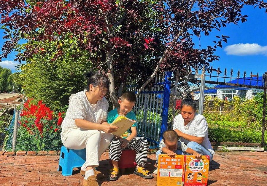 图为村民正在门前娱乐（于海静 摄）