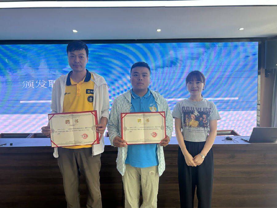 海湾社区党总支副书记郭佳丽（右一）给骑手志愿服务队颁发聘书。（周赟 摄）