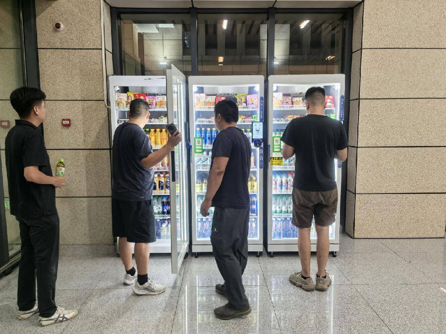 “新城快线”大冶北站旅客在自动售卖机前购买饮品（彭剑 摄）