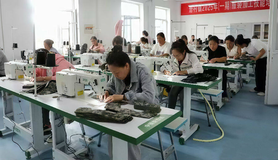 工人们认真缝制产品。（郭学红 摄）