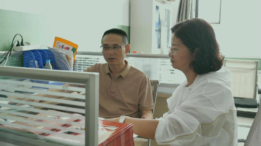 包永明与同事交流教学心得，共同探讨教学方法，为提升教学质量携手努力。 （祖丽皮耶 摄）