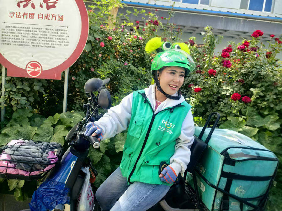 巴乐外卖员古丽努尔·阿不都赛买提说起“棉城小哥码”的功能很开心（查燕荣 摄）