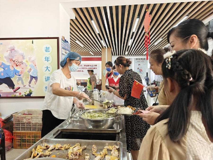 游客们在食堂内有序排队领取特色套餐（麦好明 摄）