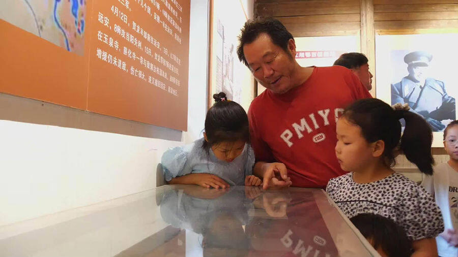 吴华正在给青少年们讲述馆藏故事（黄俊 摄）