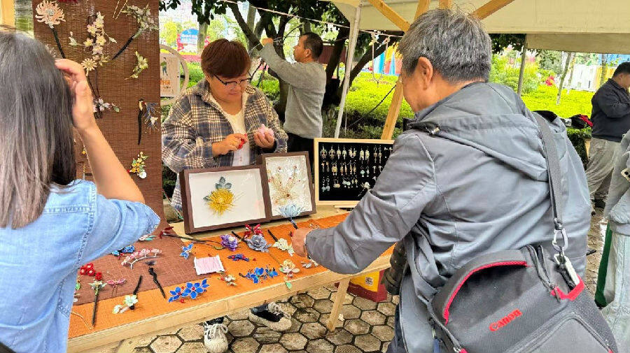 国庆期间，游客在聂燕的非遗摊位上选购商品（李光英 摄）