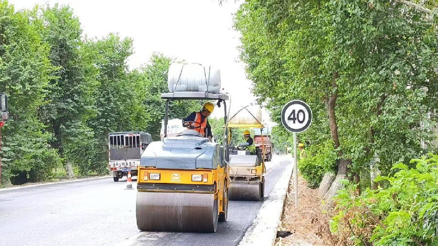 209国道路肩拓宽施工现场,压路机正在压路。(向国华 摄) 209国道路肩拓宽施工现场,压路机正在压路。(向国华 摄)