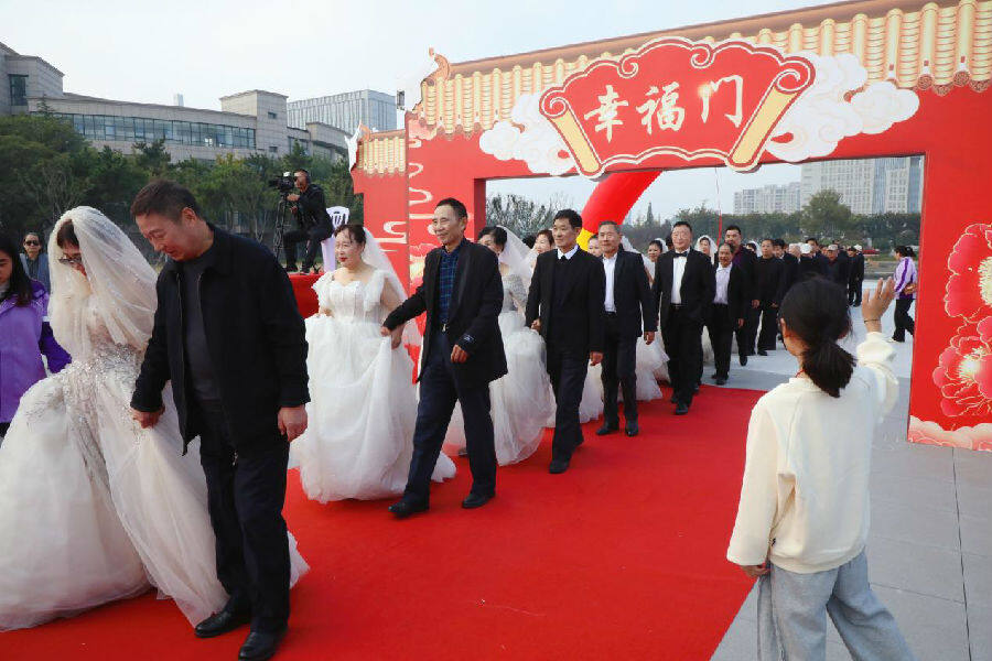 参加活动夫妇穿着婚纱礼服携手走过幸福门(张南宁 摄) 参加活动夫妇穿着婚纱礼服携手走过幸福门(张南宁 摄)