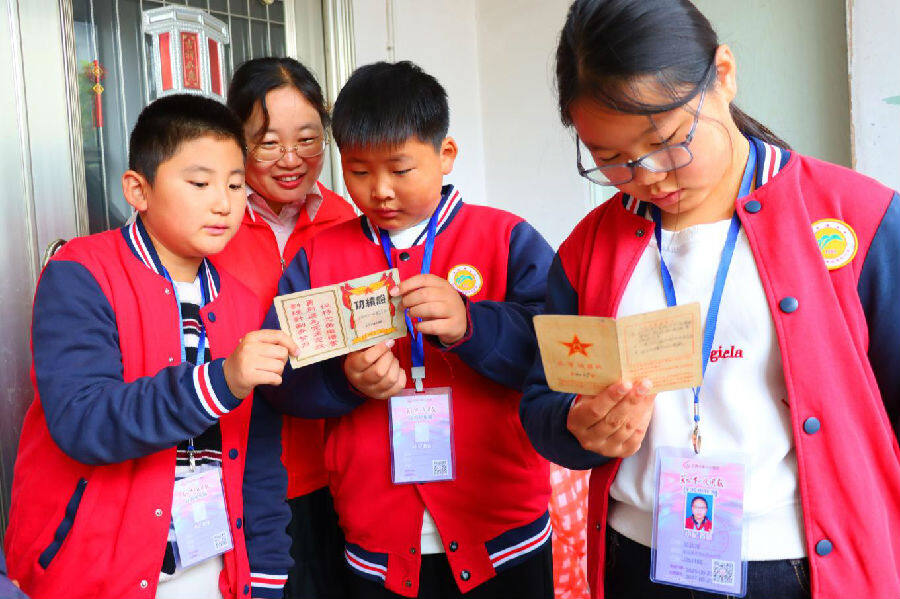 孩子们翻看老兵立功证书(张南宁 摄) 孩子们翻看老兵立功证书(张南宁 摄)
