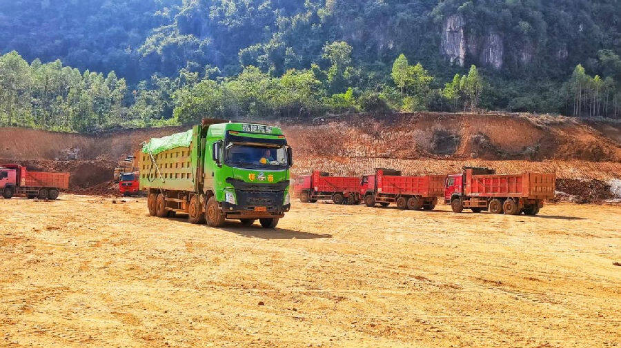 广西佳山新材料有限公司项目的建设现场，满载土方的重型卡车有序往返。（向国华 摄）