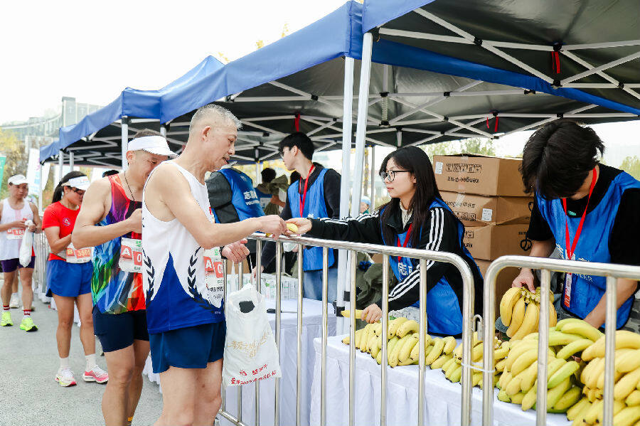 志愿者正在为选手发放补给(肖萱 摄) 志愿者正在为选手发放补给(肖萱 摄)