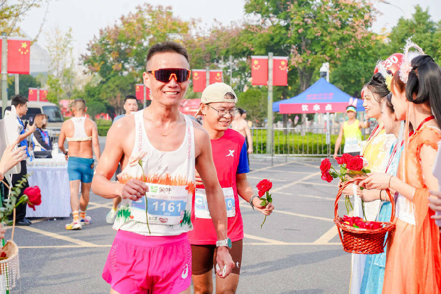 “七仙女”们为跑友赠送鲜花(肖萱 摄) “七仙女”们为跑友赠送鲜花(肖萱 摄)