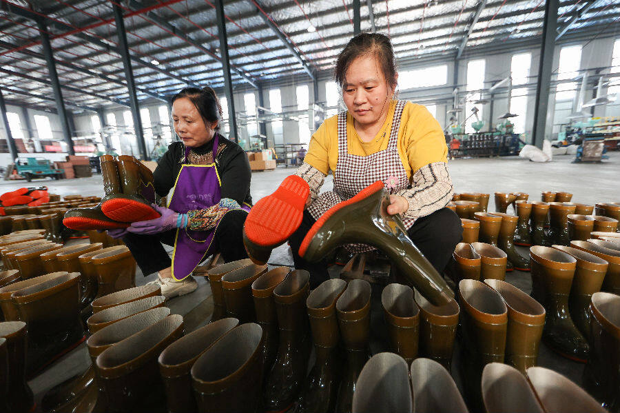 2025年10月31日，工人在赣榆区厉庄镇一家防护用品企业的雨靴生产线上工作。（司伟 摄）
