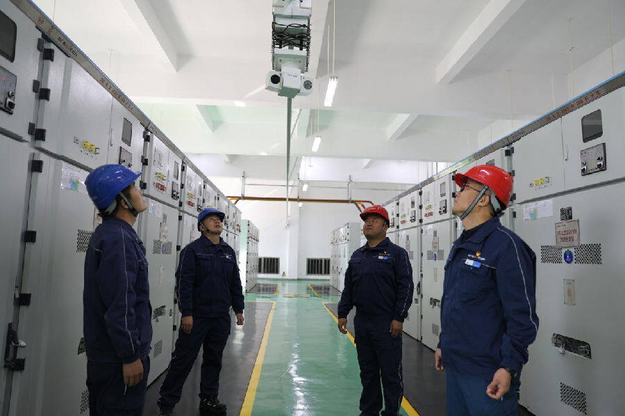 张博(右二)与一线技术人员在35KV高压室对核心设备巡检系统稳定性进行观察评估(秦英 摄) 张博(右二)与一线技术人员在35KV高压室对核心设备巡检系统稳定性进行观察评估(秦英 摄)