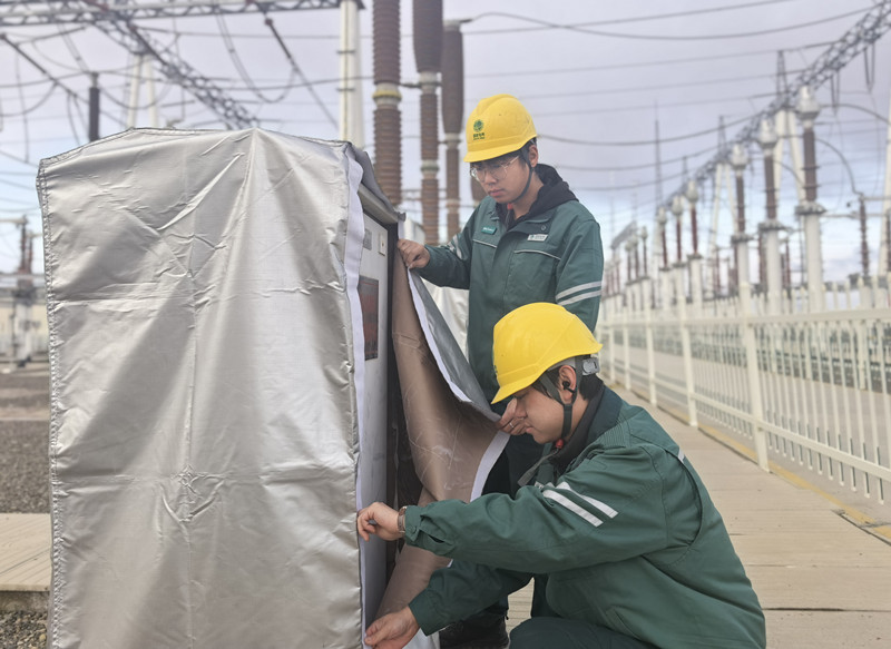 国网塔城供电公司工作人员为变电站设备穿戴保温护套。(盛虎 摄) 国网塔城供电公司工作人员为变电站设备穿戴保温护套。(盛虎 摄)
